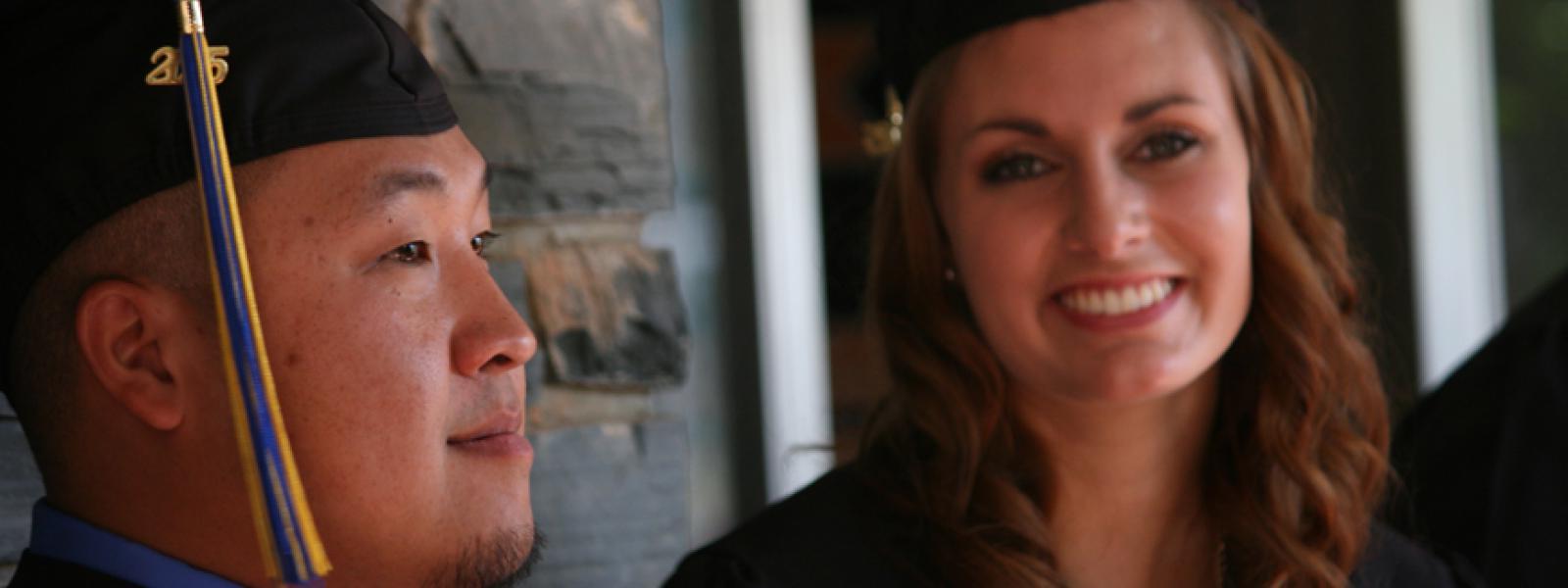 A photo of two 2015 CIU graduates. Donor scholarships allow students graduate with less debt.